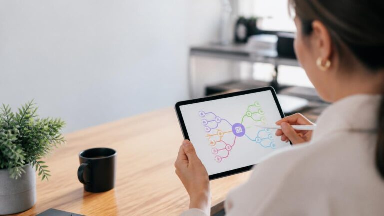 Pessoa usando tablet com um diagrama de mapa mental na tela em ambiente de trabalho moderno.