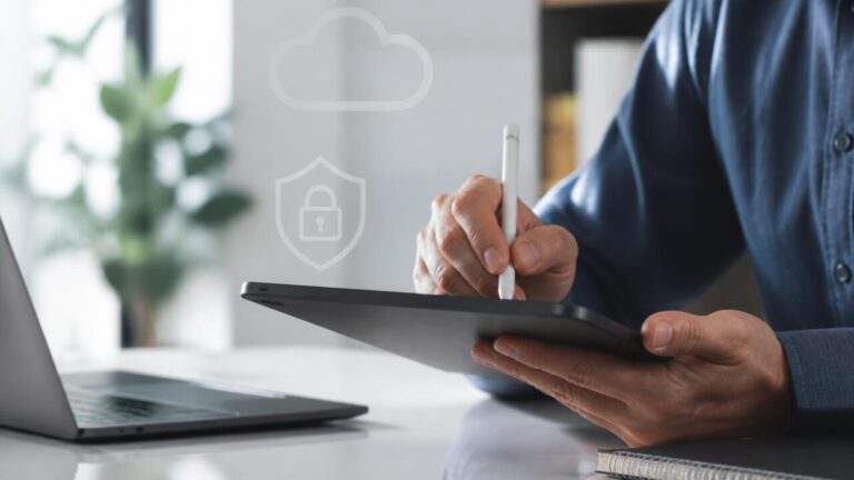 Pessoa segurando um tablet com documento digital sendo assinado na tela em ambiente de escritório moderno.